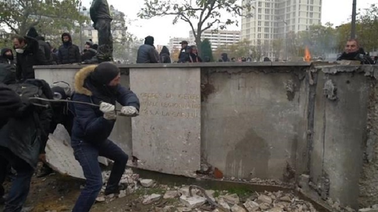 Des casseurs s'attaquent à la barre de fer au monument d'hommage situé place d'Italie à Paris.