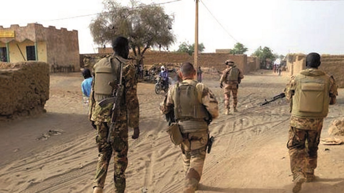 Des militaires maliens et français patrouillent dans une rue de Ménaka au Mali le 21 mars
