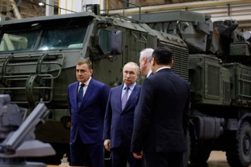 Le président russe Vladimir Poutine (au centre), accompagné du gouverneur de la région de Toula Alexey Dyumin (à gauche), visite l'usine de construction de machines Shcheglovsky Val, à Toula, le 23 décembre 2022.