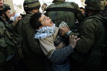Un enfant palestinien détenu par des soldats israéliens lors d'une manifestation. ©AP